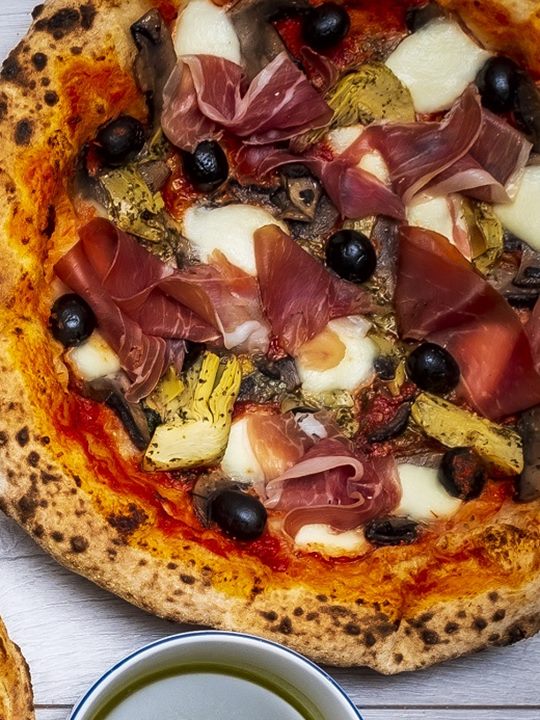 Capricciosa pizza: prosciutto crudo, artichoke, black olives, mushrooms and mozzarella